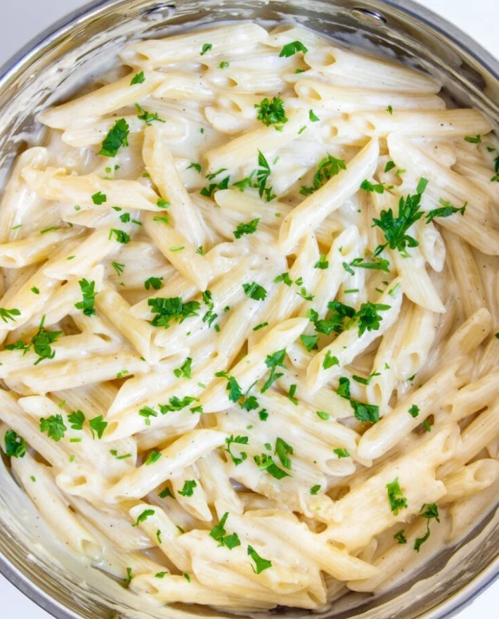 One Pot Creamy Garlic Pasta dish served with garlic bread and parmesan cheese