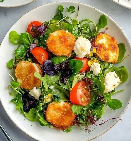Spring salad featuring fresh greens and crispy goat cheese