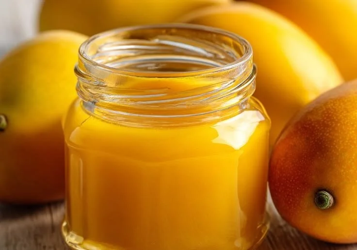 Homemade mango sauce served in a bowl with fresh mango pieces