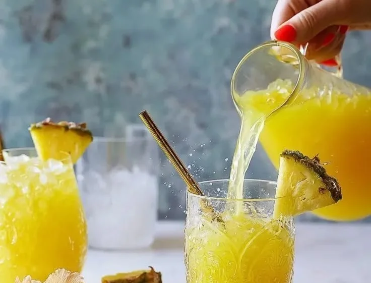 Glass of refreshing pineapple fresh water with tropical garnishes