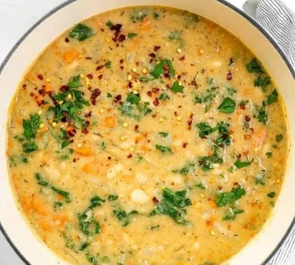 Bowl of Tuscan White Bean Soup topped with herbs and served warm
