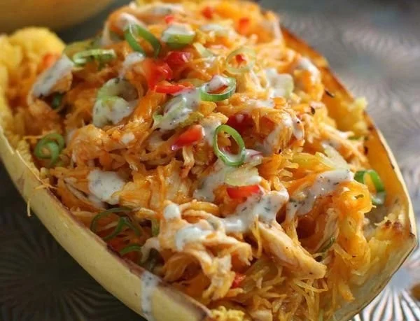 Buffalo Chicken stuffed in spaghetti squash topped with cheese and herbs