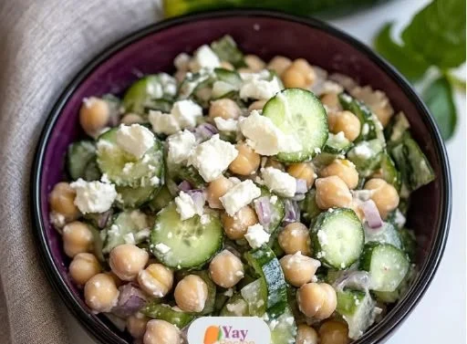 Chickpea Feta Cucumber Salad in a bowl, garnished with fresh herbs.