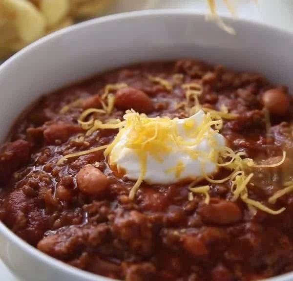 Bowl of classic homemade chili garnished with fresh herbs and toppings.
