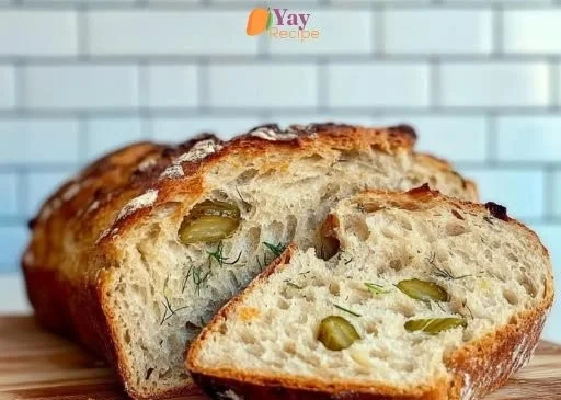 Loaf of dill pickle sourdough bread on a wooden cutting board