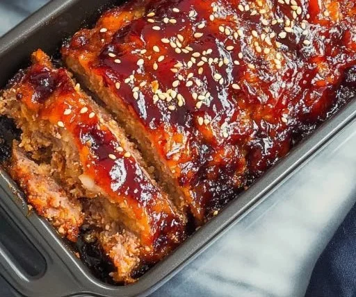 Korean meatloaf glazed with gochujang, garnished with sesame seeds and scallions.