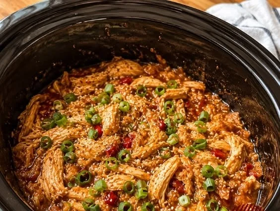 Delicious slow cooker firecracker chicken garnished with green onions.