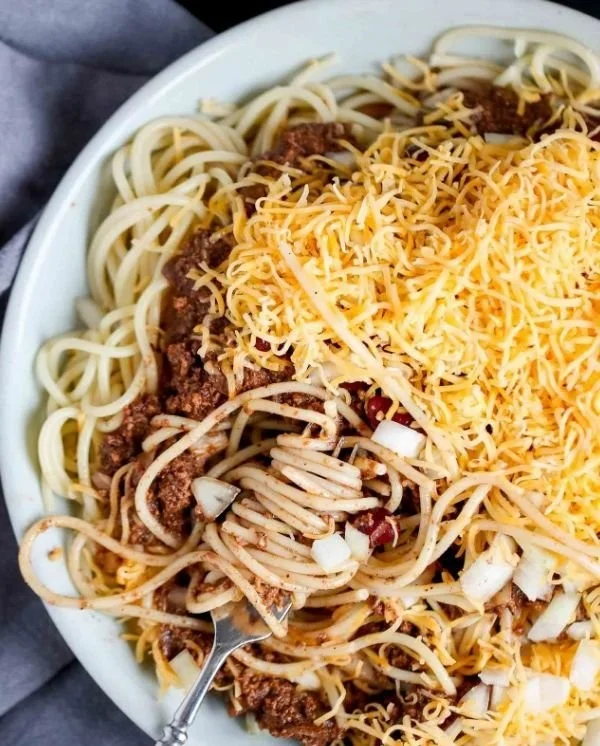 Delicious homemade Cincinnati chili served in a bowl with cheese and onions