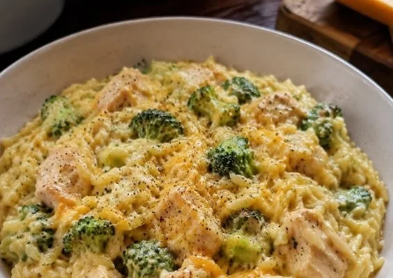 Bowl of Chicken Broccoli Cheddar Orzo with chicken pieces, broccoli, and shredded cheese